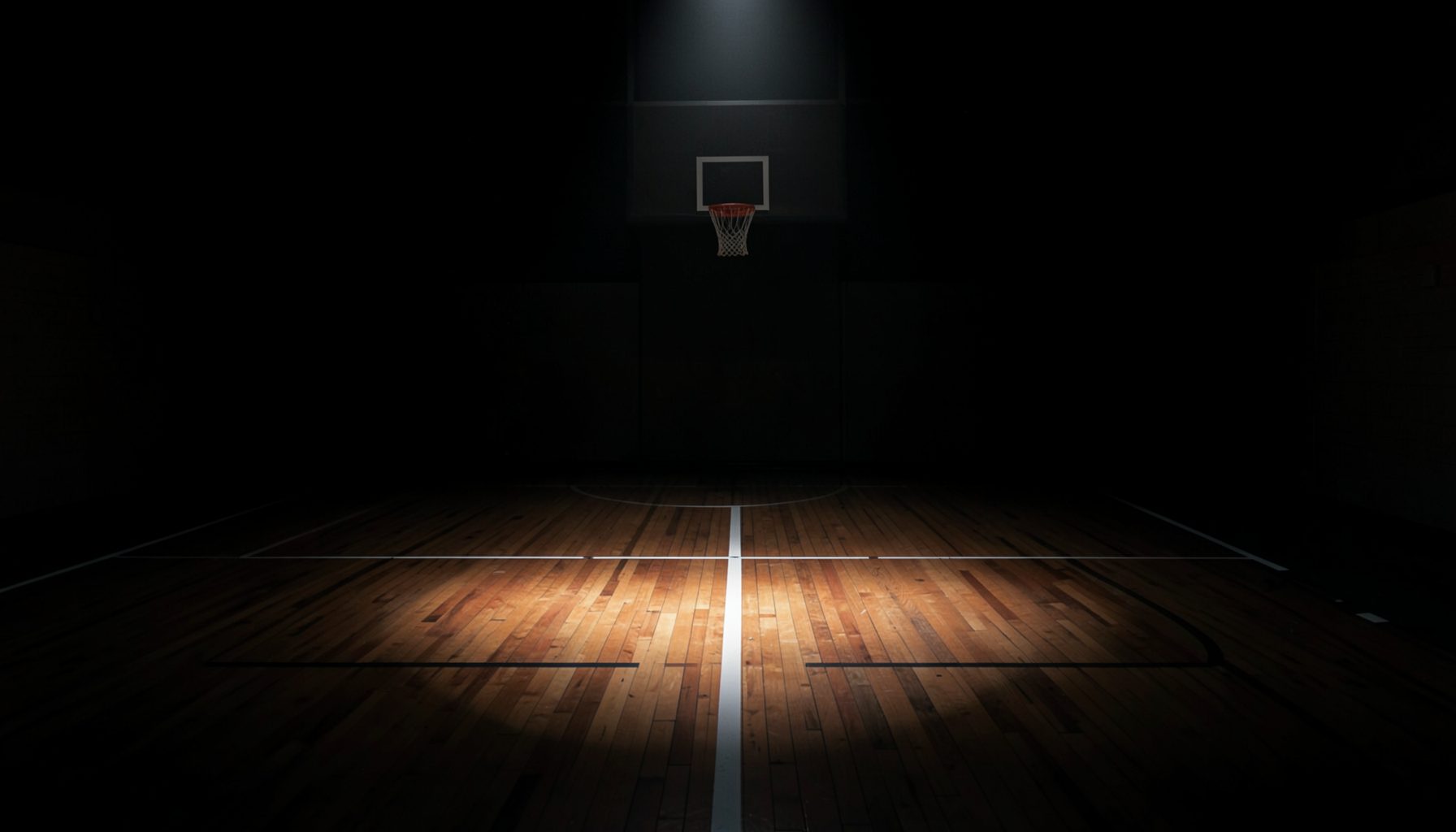Dark atmospheric basketball court with a single spotlight on the hardwood floor, deep blacks and muted warm tones